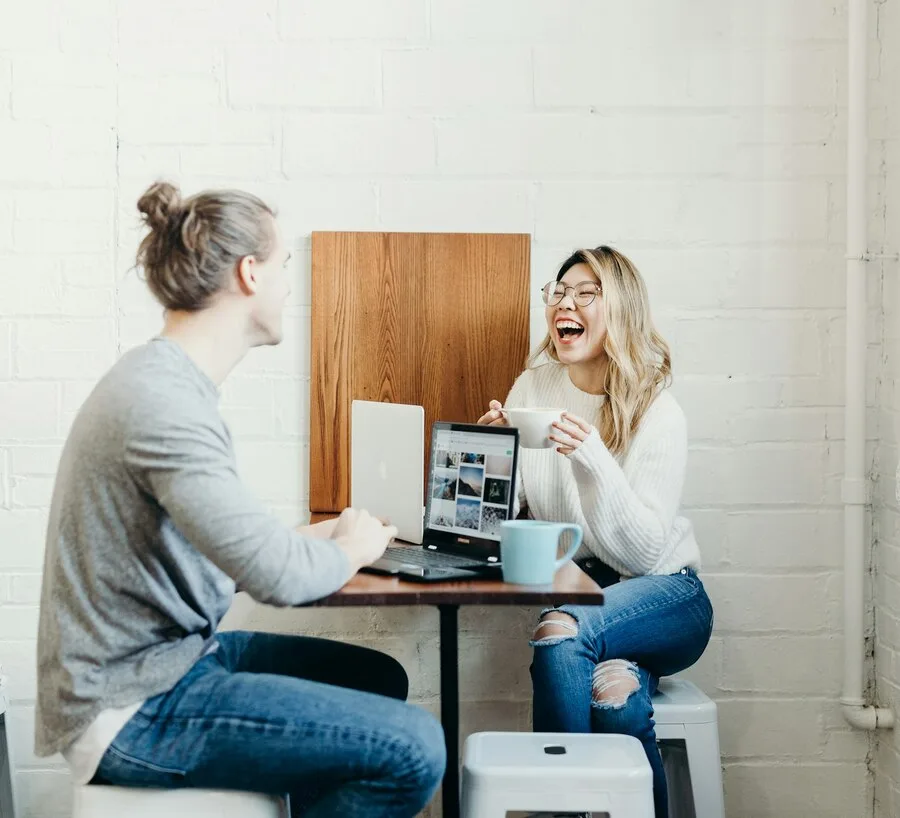 Genuine laughter during a first date conversation over coffee, illustrating real engagement over rehearsed lines