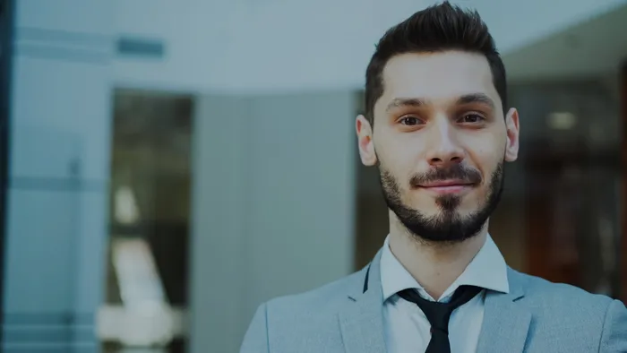 Confident, well-dressed professional man smiling in a modern office