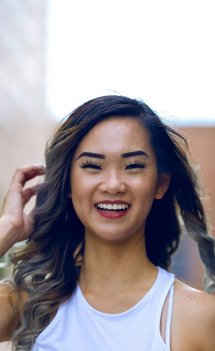 Genuine, warm smile from a woman enjoying a sunny day outdoors