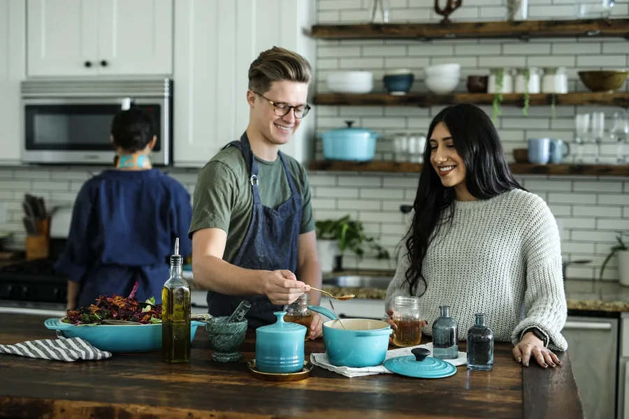 Couple cooking together at home, showing relaxed dating for a busy professional schedule