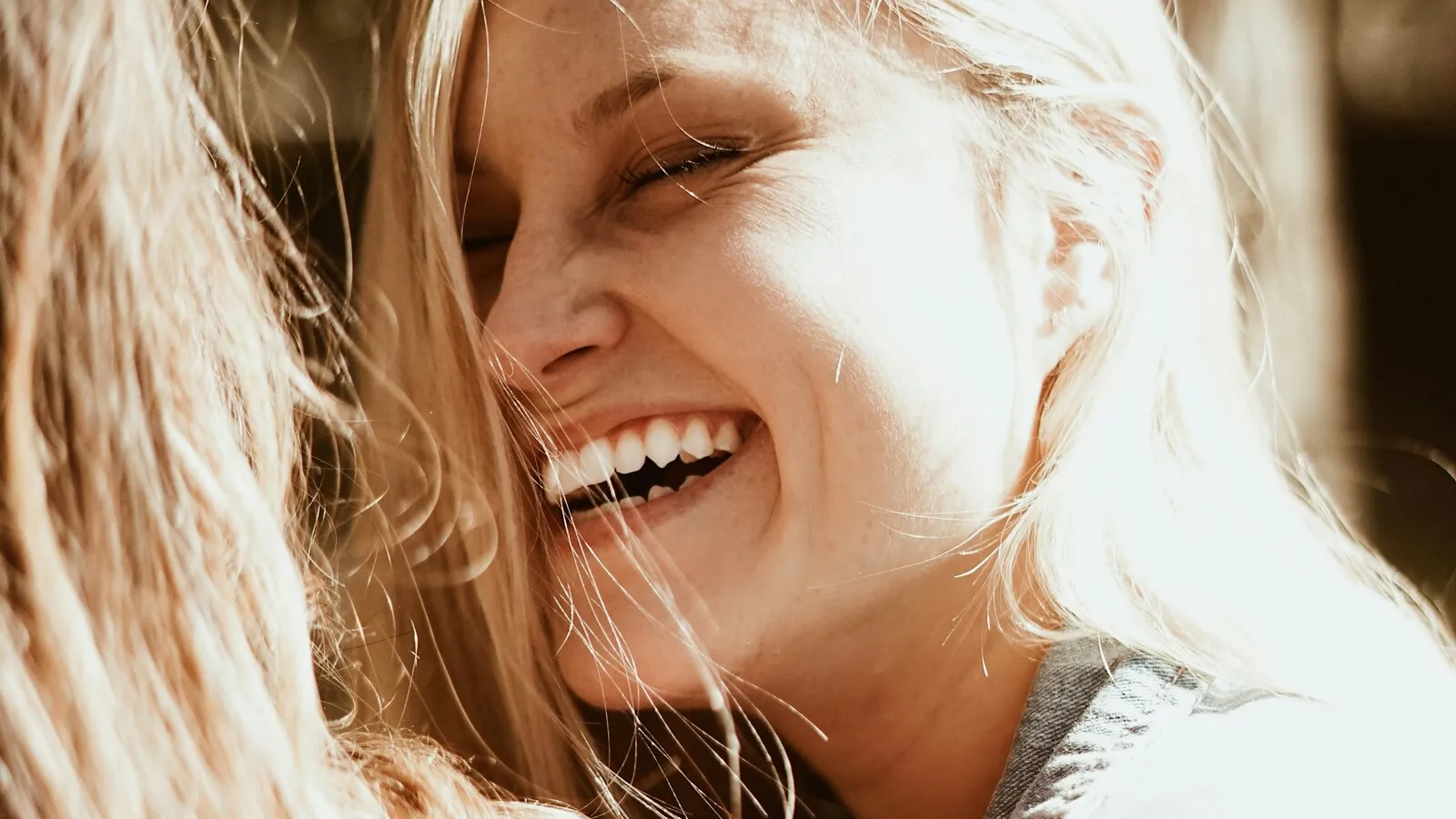 Woman with a genuine, warm smile, illustrating real interest versus interest driven by success